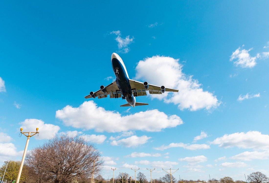 How National Air Traffic Control Services Keep UK Skies Safe and Efficient cover Airplane flying underneath a blue sky.