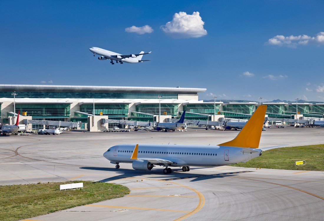 A busy airport with mutiple airplanes in action.